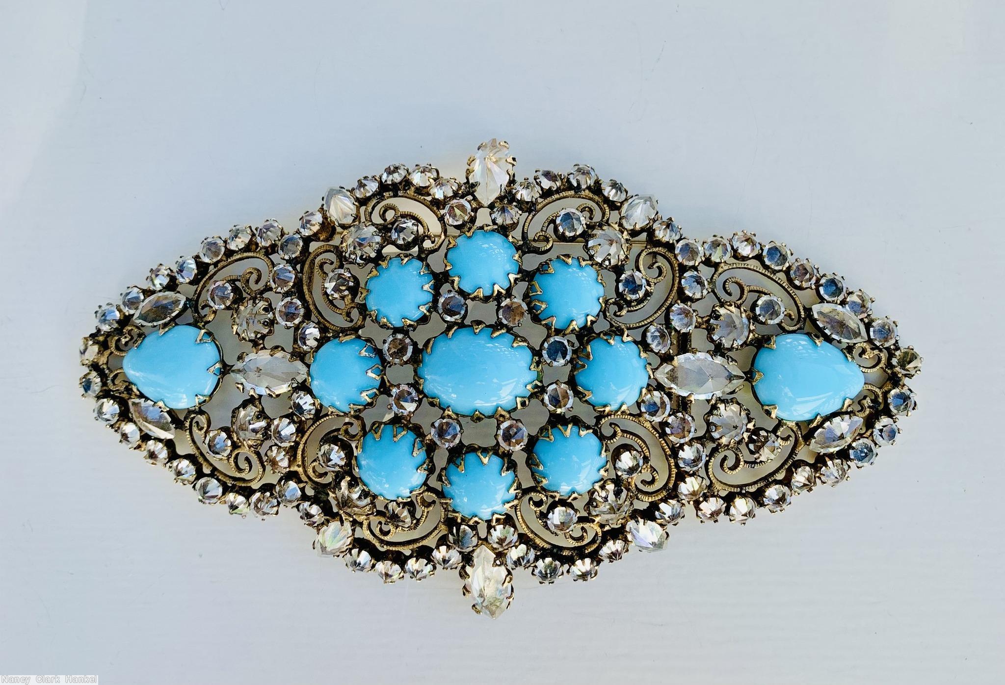 Schreiner diamond shaped radial scrollwork buckle bordered small invert stone oval cab center 8 surrounding round cab 2 large teardrop at end opaque baby blue round cab crystal inverted goldtone jewelry