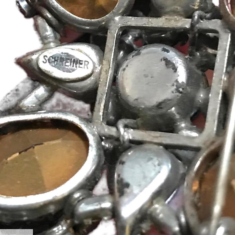 Schreiner 2 level radial maltese pin bottom 4 large oval 4 half acorn cluster 4 teardrop top round center 7 teardrop surrounding ruby navy bicolor faceted round center stone pale pink teardrop large ab teardrop purple large oval faceted oval stone ab chaton fuschia chaton crystal chaton jewelry