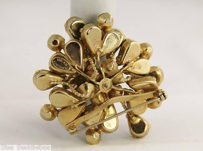 Schreiner 2 level radial pin top level small chaton center 6 surrounding small oval stone bottom level 6 long branch of single teardrop 6 branch of 3 stone emerald jewelry