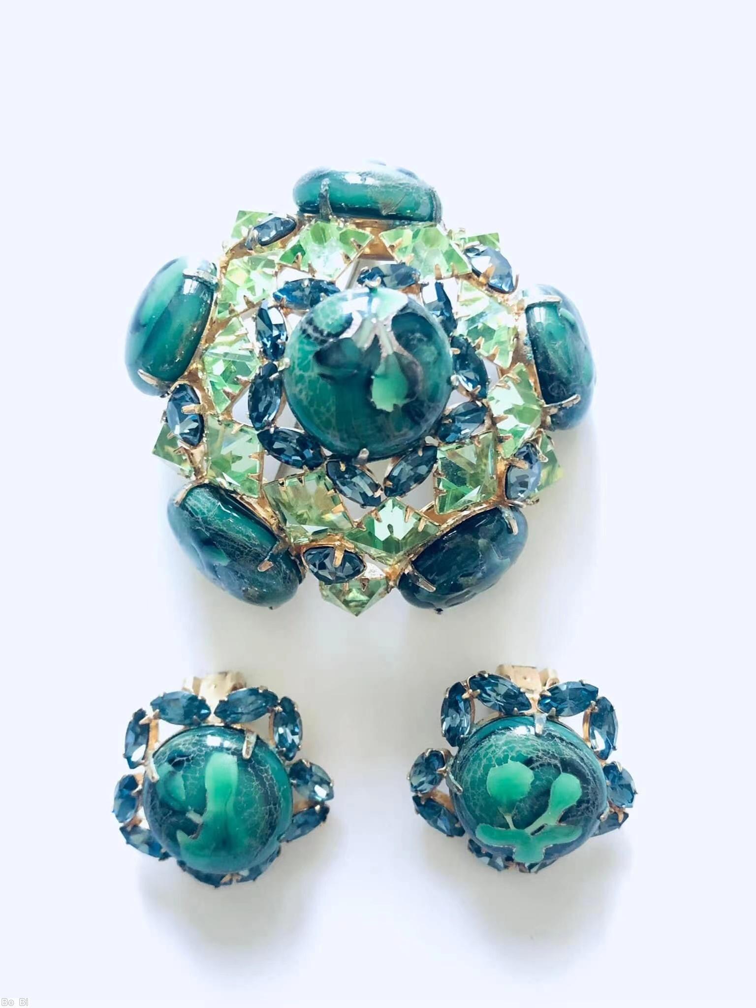 Schreiner 3 rounds domed radial pin 6 large round art glass stone 8 surrounding tilted navette 2nd round 10 faceted square stone side wall 5 large round stone marbled green large round cab celery faceted square stone blue small faceted navette goldtone jewelry