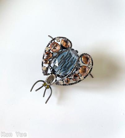 Schreiner bug 2 wing 4 whisker large round stone body 2 curly wire leg each wing 7 varied size stone 2 small chaton eye small oval stone head rose cut smoky blue large round stone topaz inverted faceted chaton peridot eye small chaton silvertone jewelry