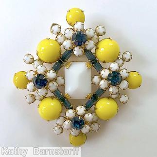 Schreiner diamond shaped radial pin elongated hexagon center stone 4 large round cab 4 flower head of 6 chatons surrounding 1 chaton 8 small baguette 4 small round cab lime round cab navy small buguette milk white chaton goldtone jewelry