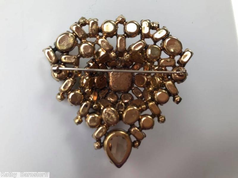 Schreiner domed triangle shaped pin large square stone center 1 large teardrop small baguette 4 surrounding small baguette 2 surrounding oval stone 4 surrounding chaton clear brown faceted teardrop crystal smoke goldtone jewelry