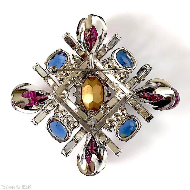 Schreiner fancy cross radial pin 2 by 2 baguette row 4 large art glass large oval cab center 4 oval cab 12 small teardrop lavender art glass purpla large oval center peach navy oval cab navy small baguette silvertone jewelry