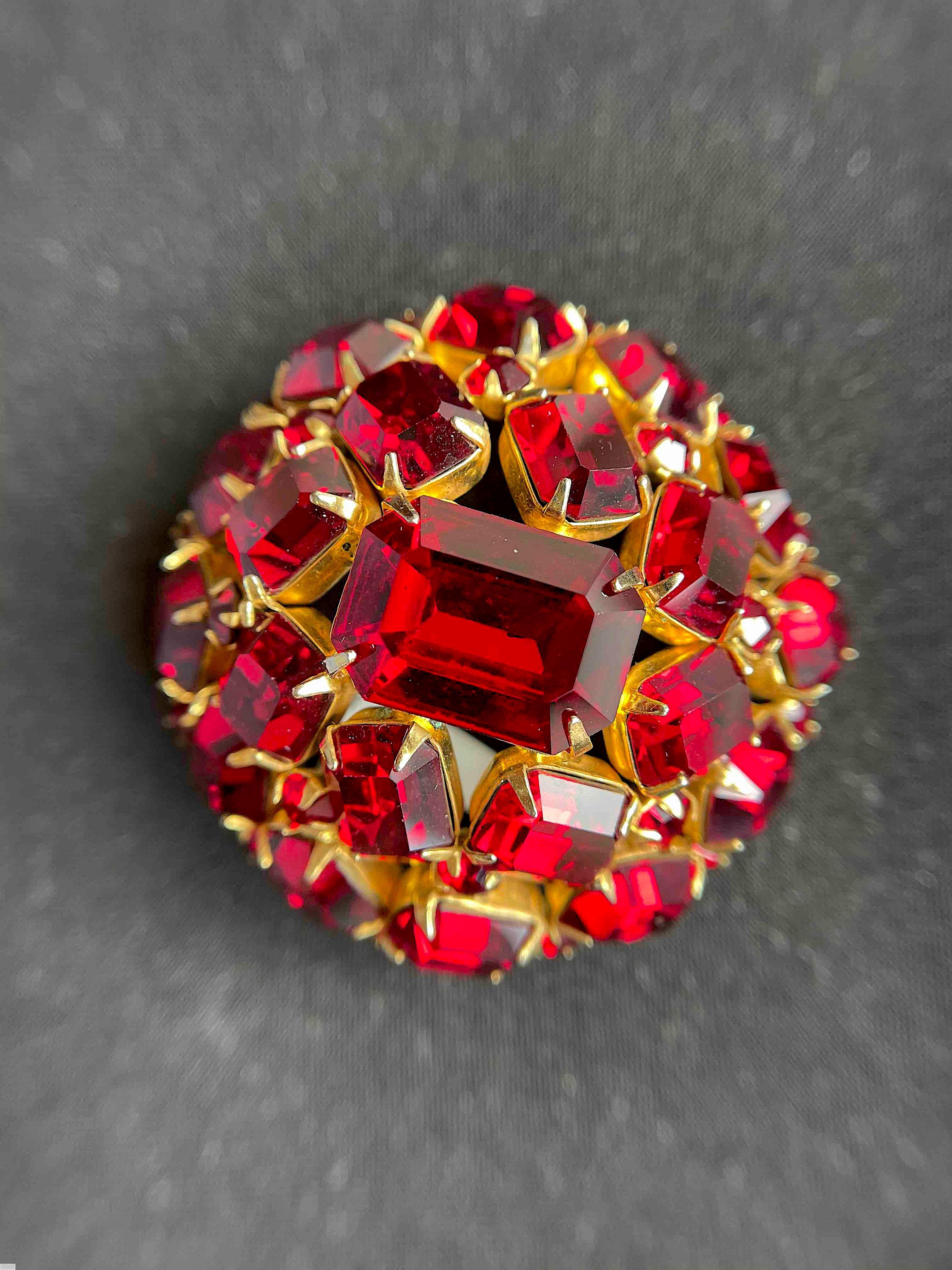 Schreiner high domed oval 20 emerald cut stone pin large emerald cut center 8 surrounding stone 12 second round stone small chaton clear red goldtone jewelry