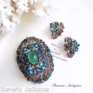 Schreiner highly domed oval shaped pin 1 large oval cab center 8 scrollwork 8 small surrounding navette green large oval cab babyblue opaque chaton goldtone navy blue inverted stone jewelry