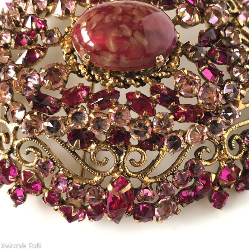 Schreiner highly domed oval shaped pin 1 large oval cab center 8 scrollwork 8 small surrounding navette large oval marbled carnelian cab center clear fuchsia small navette clear peach inverted stone goldtone jewelry