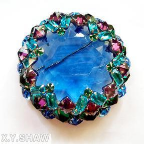Schreiner large faceted open back center domed round pin 8 waves of seeds 16 oval stone side clear navy hexagonal faceted crystal center purple inverted square stone aqua clear faceted baguette opaque baby blue small chaton emeral colored emerald cut stone goldtone jewelry
