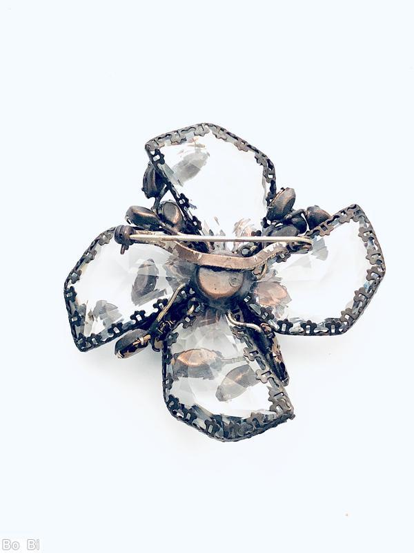 Schreiner radial 2 level pin bottom 4 large surrounding swirling faceted semicircle crystal with irregular edge top chaton center 4 surrounding flower head 4 surrounding small navette 4 small bush branch of small navette large faceted crystal brown metalic chaton gold flussed brown small navette peridot small chaton gunmetal coating on copper back jewelry