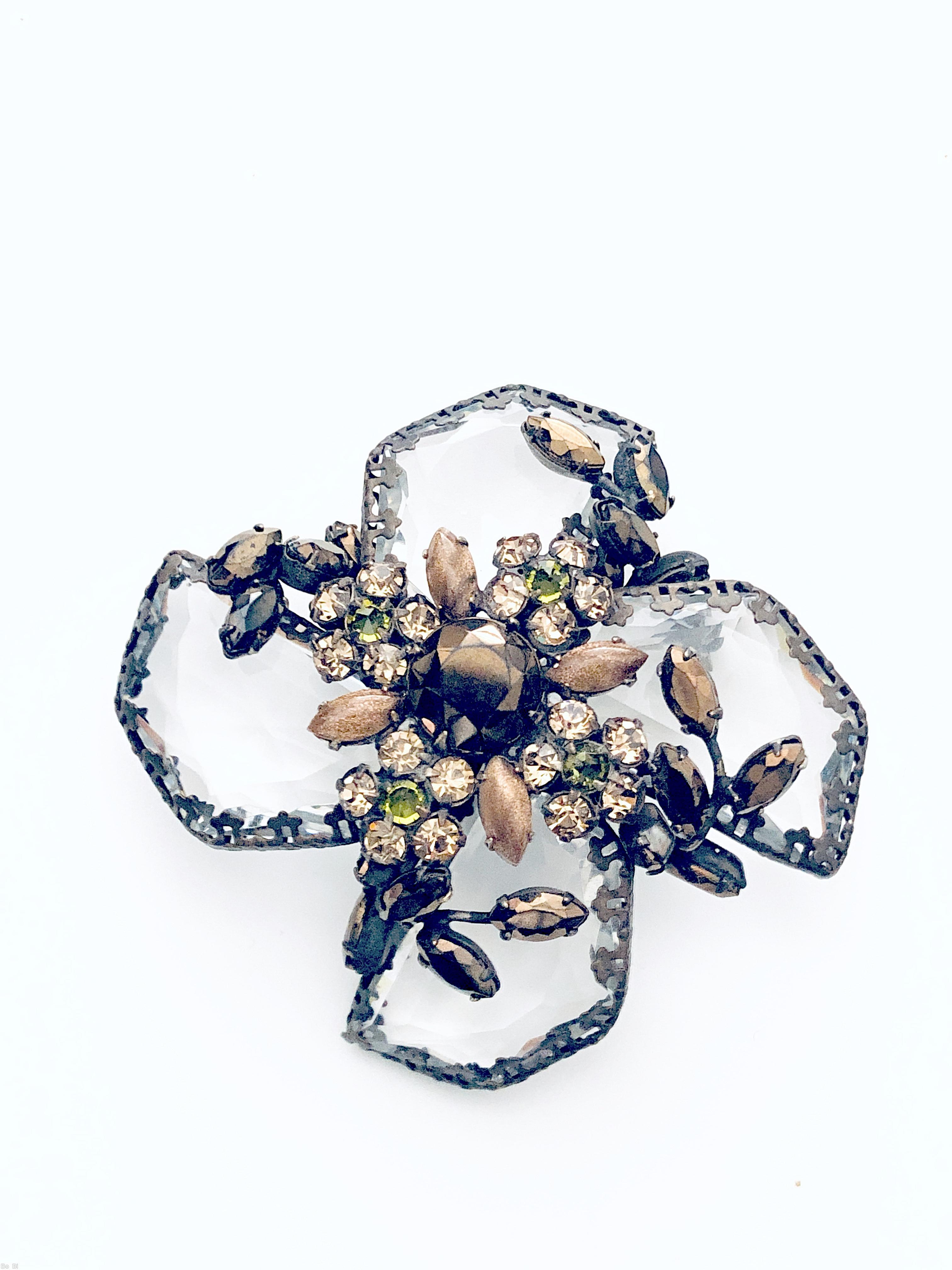 Schreiner radial 2 level pin bottom 4 large surrounding swirling faceted semicircle crystal with irregular edge top chaton center 4 surrounding flower head 4 surrounding small navette 4 small bush branch of small navette large faceted crystal brown metalic chaton gold flussed brown small navette peridot small chaton gunmetal coating on copper back jewelry