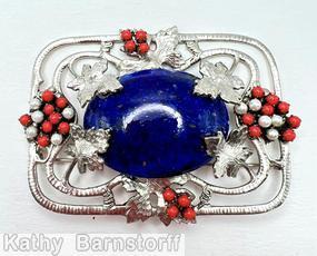 Schreiner rectangle metal deco grape pin 6 molded metal grape leaf covered large oval cab center 2 groups of 4 small round cab 2 groups of 13 small round stone 8 metal wire border with marks large oval lapis cab center red small round cab small faux pearl molded large grape leaf silvertone jewelry
