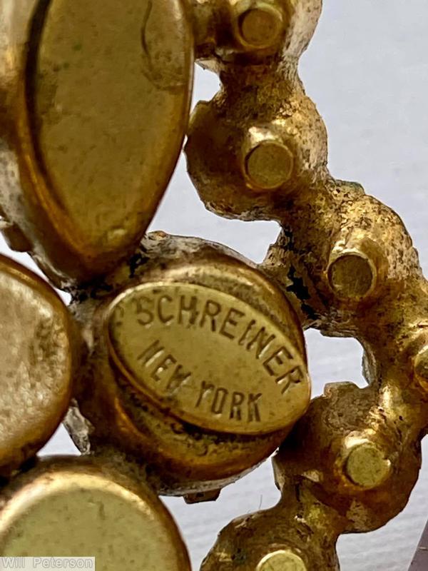 Schreiner rectangle shaped domed radial pin 4 small chaton formed circle at corner 5 large rectangle stone 12 surrounding navette large clear amethyst emerald cut center stone olivine inverted stone goldtone jewelry