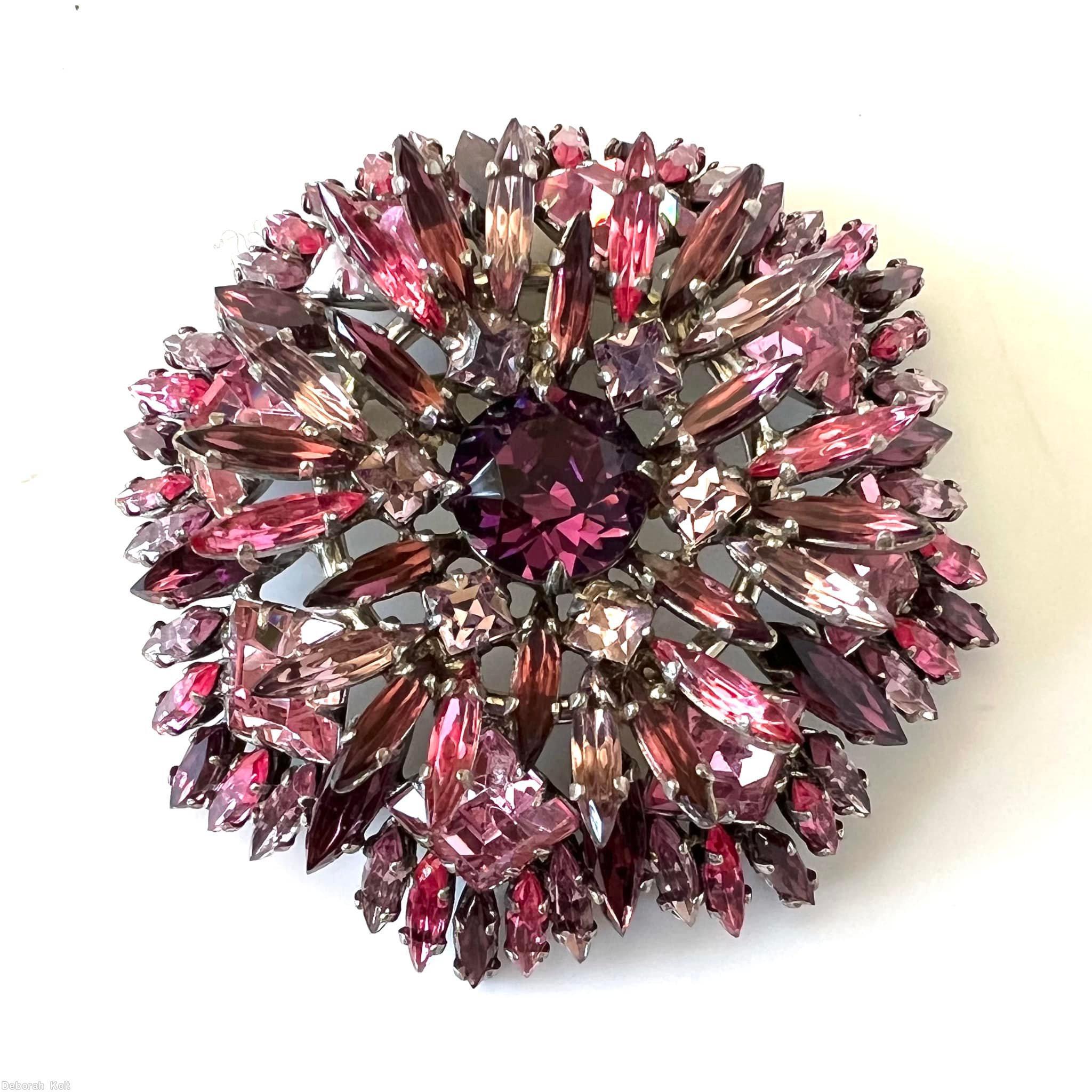 Schreiner round shaped flat top radial navette pin large chaton center 6 small square surrounding stone 6 navette surrounding stone 8 large square stone purple faceted large round stone center peach small square stone pink navette clear ice pink square stone lavender navette silvertone jewelry