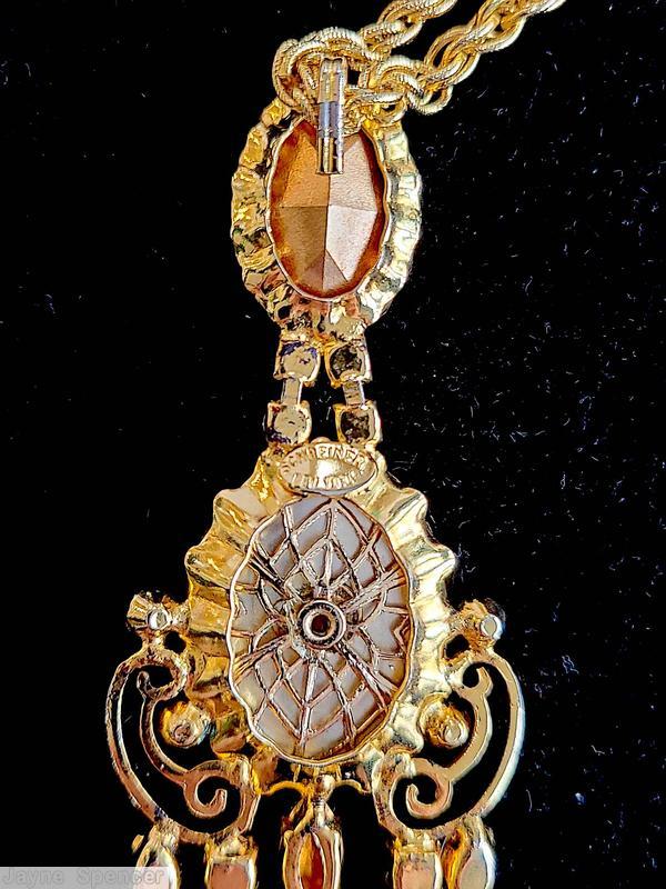 Schreiner 3 part top dangling scrollwork pendant top part oval stone cab middle part large oval cab scrollwork bottom 3 dangling teardrop connected to navette large oval baroque faux pearl large oval faceted crystal goldtone jewelry